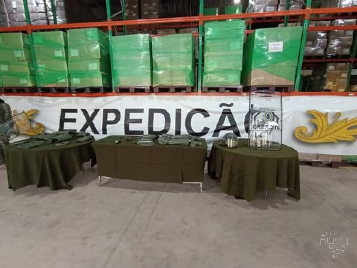 Equipamentos de proteção antitumulto expostos diante de caixas preparadas para distribuição logística